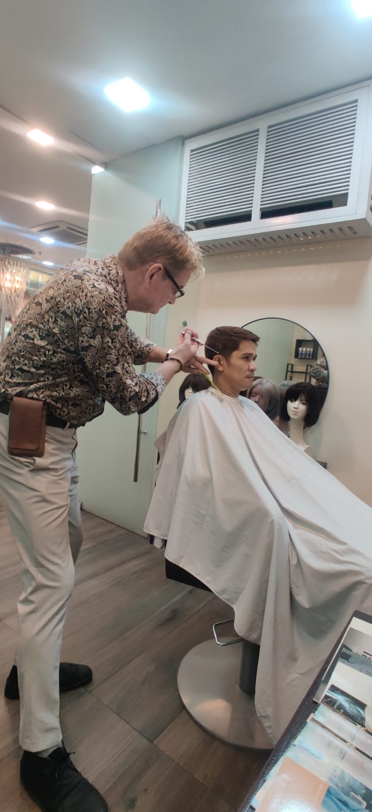 Michael Müller cutting in a new men’s hair system for a client at the HEADS studio in Makati