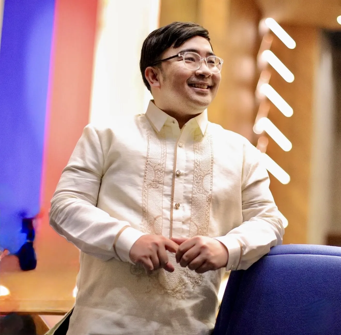 Real HEADS client in a barong, smiling after his hair system fitting