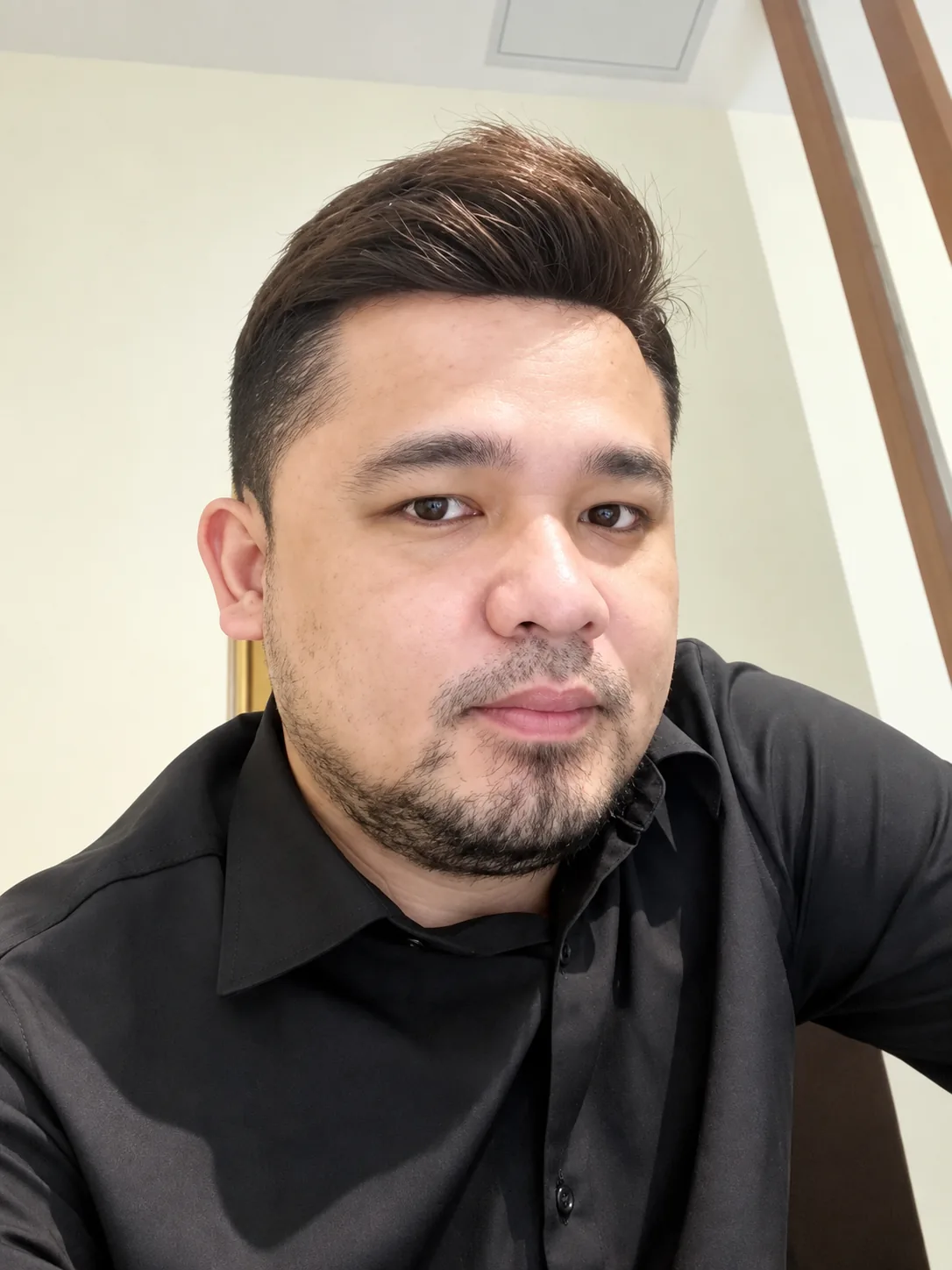Real HEADS client taking a selfie with his natural men's hair system, dark shirt