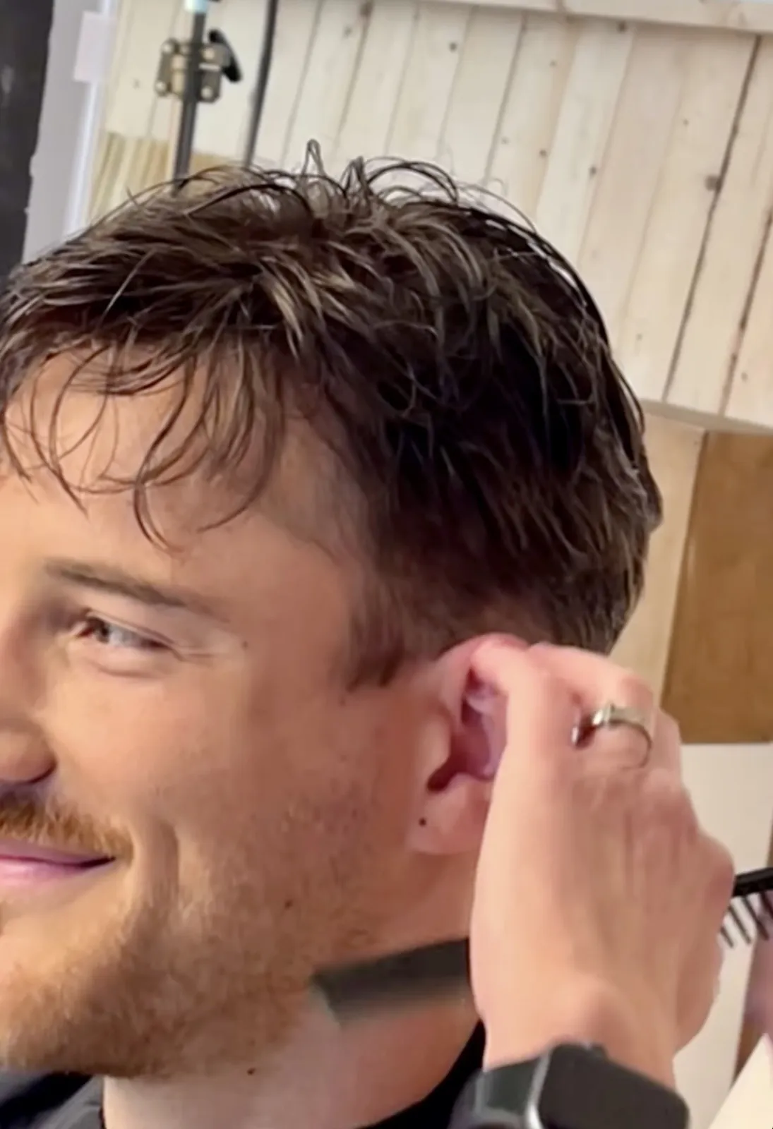 Real HEADS client smiling during the final styling of his hair system